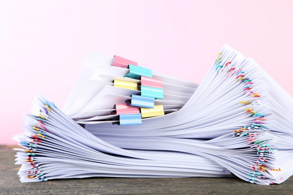 Designing an effective product research form makes the process simpler. The images shows a physical representation of product research form, stacks of paper.