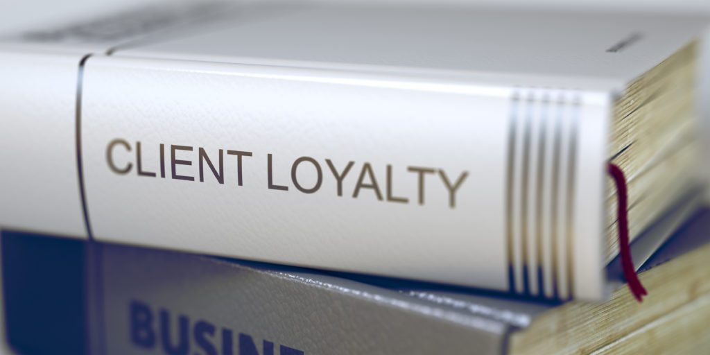 Image shows a book with the words client loyalty written on it representing the benefits of the Net Promoter Score (NPS).