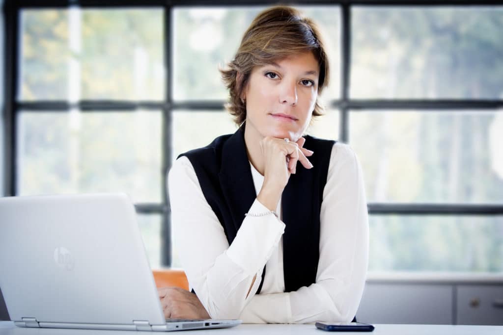 Image shows HR professional, Berta Maso, sitting at a desk.